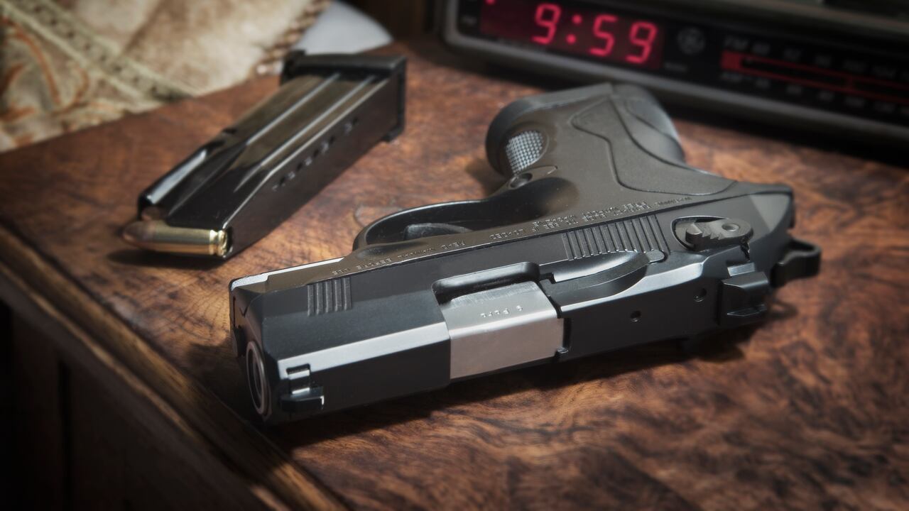 Pistola semiautomática Beretta PX4 Storm de 9 mm en la mesita de noche junto a la cama