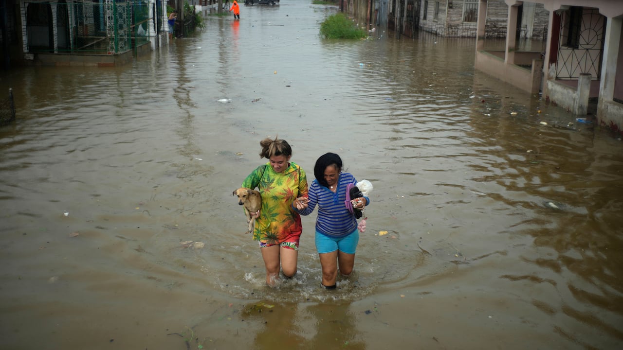 Los residentes caminan por una calle inundada por las lluvias provocadas por el huracán Idalia, en Batabano, Cuba, el martes 29 de agosto de 2023. Idalia se fortaleció hasta convertirse en huracán el martes y se dirigió hacia la costa del Golfo de Florida.