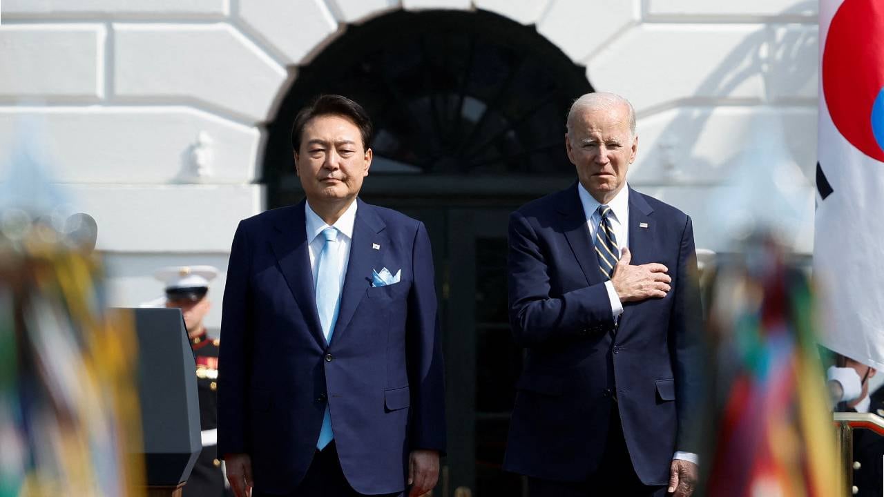 El presidente de EE. UU., Joe Biden, y el presidente de Corea del Sur , Yoon Suk Yeol, escuchan juntos los himnos nacionales de sus países durante una ceremonia oficial de llegada al estado de la Casa Blanca.