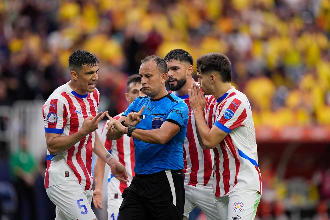 Paraguay's players argue with referee Dario Herrera of Argentina during a Copa America Group D soccer match against Colombia in Houston, Monday, June 24, 2024. (AP Photo/David J. Phillip)