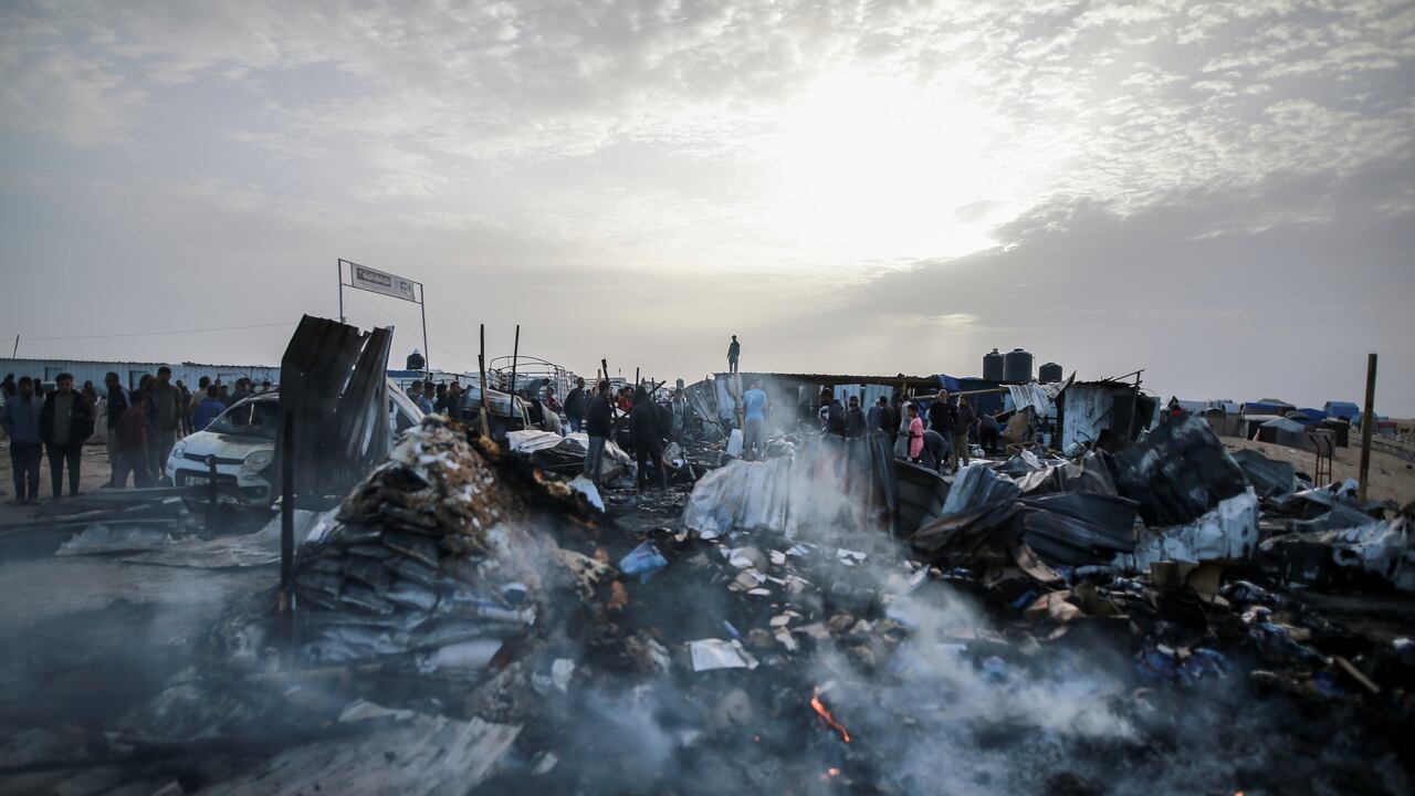 Los palestinos observan la destrucción después de un ataque israelí donde se alojaban personas desplazadas en Rafah, Franja de Gaza, el lunes 27 de mayo de 2024.