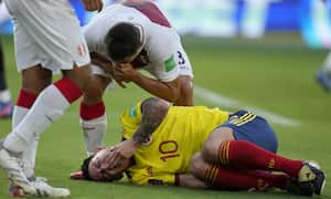 Peru's Aldo Corzo taunts Colombia's James Rodriguez after falling on the pitch during a qualifying soccer match for the FIFA World Cup Qatar 2022 at the Roberto Melendez stadium in Barranquilla, Colombia, Friday, Jan. 28, 2022. (AP Photo/Fernando Vergara)