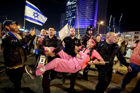 Un hombre detenido reacciona mientras la policía lo lleva durante una manifestación contra la reforma judicial del gobierno de coalición nacionalista de Israel, luego de un discurso televisado pronunciado por el primer ministro israelí Benjamin Netanyahu, en Tel Aviv