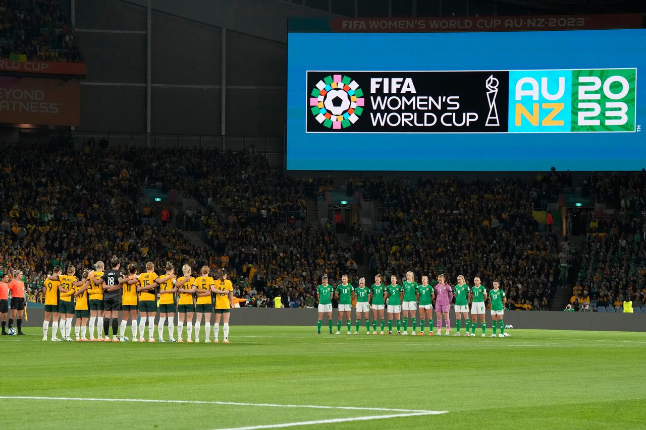 Las jugadoras de Australia, izquierda, e Irlanda guardan un momento de silencio por las víctimas del reciente tiroteo en Nueva Zelanda antes del partido de fútbol de la Copa Mundial Femenina entre Australia e Irlanda en el Estadio Australia en Sídney, Australia, el jueves 20 de julio de 2023. (Foto AP/Rick Rycroft)