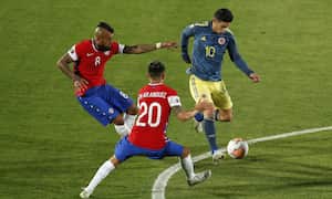 SANTIAGO, CHILE - OCTOBER 13: James Rodríguez of Colombia fights for the ball with Arturo Vidal and Charles Aránguiz of Chile during a match between Chile and Colombia as part of South American Qualifiers for Qatar 2022 at Estadio Nacional de Chile on October 13, 2020 in Santiago, Chile. (Photo by Alberto Valdes-Pool/Getty Images)