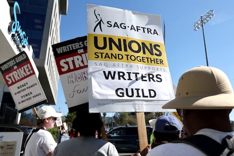 LOS ANGELES, CALIFORNIA - JULY 13: A sign reads 'Unions Stand Together' as SAG-AFTRA members walk the picket line in solidarity with striking WGA (Writers Guild of America) workers outside Netflix offices on July 13, 2023 in Los Angeles, California. Members of SAG-AFTRA, Hollywood�s largest union which represents actors and other media professionals, will likely go on strike after a midnight deadline over contract negotiations with studios expired. The strike could shut down Hollywood productions completely with writers in the third month of their strike against Hollywood studios.   Mario Tama/Getty Images/AFP (Photo by MARIO TAMA / GETTY IMAGES NORTH AMERICA / Getty Images via AFP)