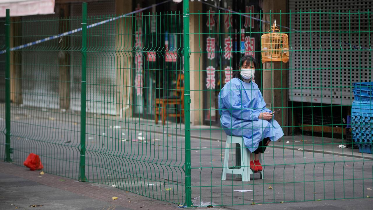 Un trabajador con traje de protección se sienta detrás de una barrera en una zona sellada tras el brote de la enfermedad por coronavirus (COVID-19), en Shanghái, China, el 11 de octubre de 2022. REUTERS/Aly Song