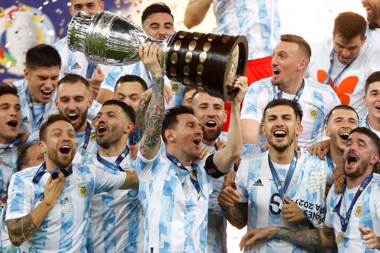 El argentino Lionel Messi sostiene el trofeo mientras celebra con sus compañeros de equipo después de vencer 1-0 a Brasil en la final de la Copa América en el estadio Maracaná de Río de Janeiro, Brasil, el sábado 10 de julio de 2021 (AP Photo / Andre Penner).