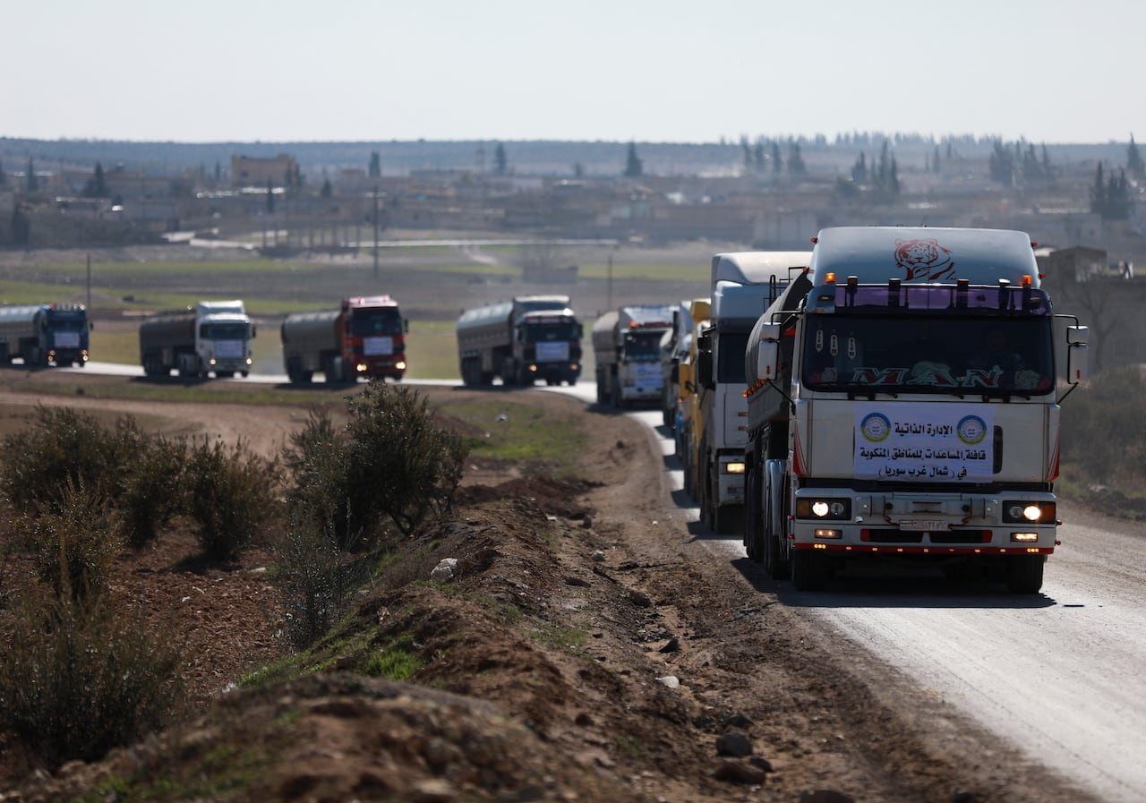 Los camiones que llevan ayuda humanitaria de los kurdos conducen al cruce, para ser llevados al noroeste de Siria, en el campo de Manbij, Gobernación de Alepo, tras el terremoto