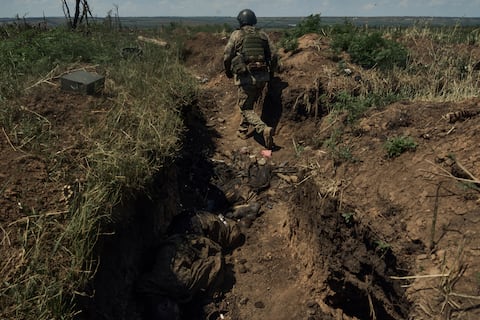 Un soldado ucraniano recorre una trinchera recientemente recuperada con cuerpos de soldados rusos, cerca de Bájmut, Ucrania