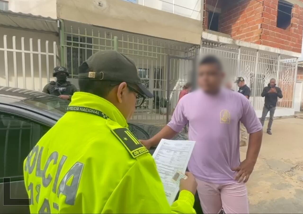 Policía lee los derechos a uno de los capturados en redada contra red de tráfico de migrantes.