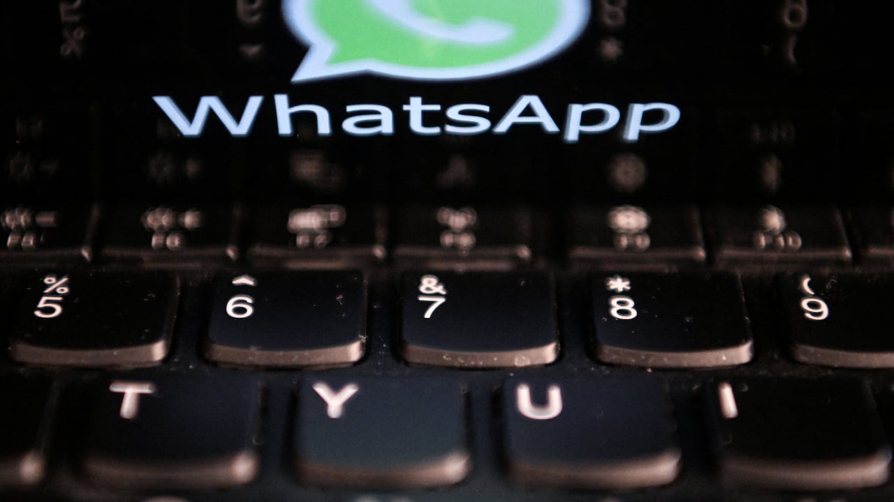 This photo illustration shows a woman checking the settings of the messaging application WhatsApp