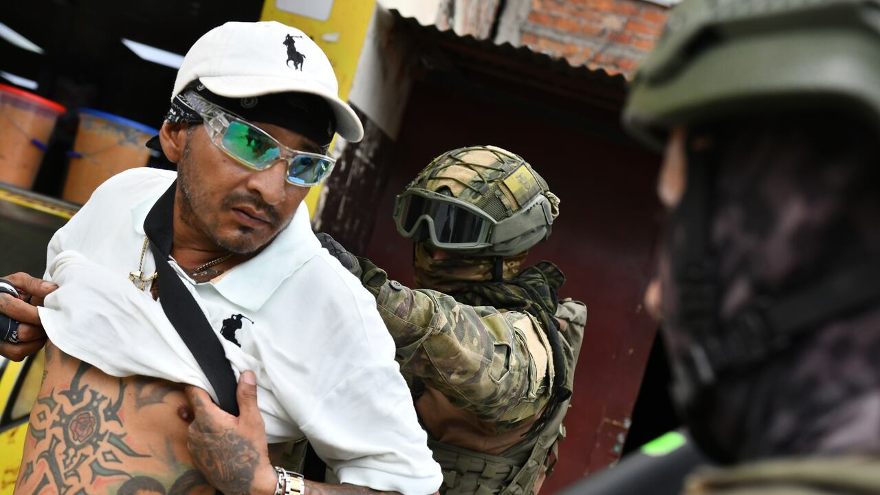 Un soldado examina la espalda de un hombre buscando tatuajes relacionados con pandillas, durante una operación de detención y cacheo en Portoviejo, Ecuador, el jueves 11 de enero de 2024.