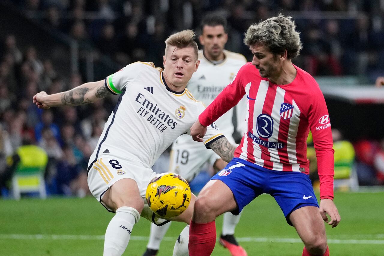 Atletico Madrid's Antoine Griezmann, right, and Real Madrid's Toni Kroos challenge for the ball during the Spanish La Liga soccer match between Real Madrid and Atletico Madrid at the Santiago Bernabeu stadium in Madrid, Spain, Sunday, Feb. 4, 2024. (AP Photo/Bernat Armangue)