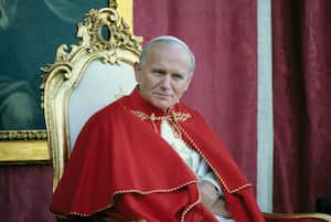 11/2/1982- Avila, Spain: Close-up of Pope John Paul II sitting on a chair, wearing red robes with a portrait of the St. Theresa of Avila in the background during his visit to Avila, Spain.