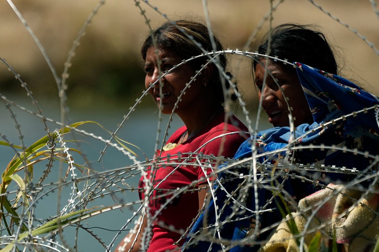 Migrante que vadearon el Río Bravo para cruzar de México a Estados Unidos se encuentran con un alambre con concertinas, o cuchillas, el 21 de septiembre de 2023, en Eagle Pass, Texas.