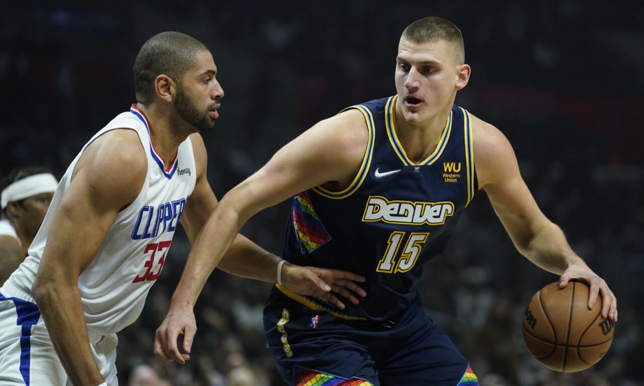 El alero de los Clippers de Los Ángeles, Nicolas Batum, defiende al pívot de los Nuggets de Denver, Nikola Jokic, en la primera mitad del partido del domingo 26 de diciembre de 2021, en Los Ángeles. (AP/Ashley Landis)