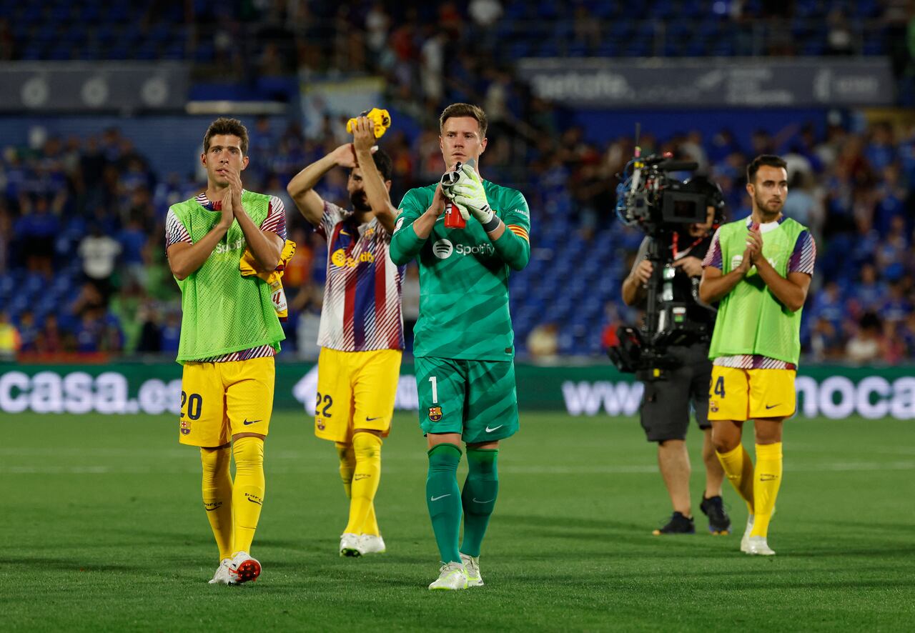 Barcelona's Spanish midfielder #20 Sergi Roberto (L) and Barcelona's German goalkeeper #01 Marc-Andre ter Stegen (C) applaud at the end of the Spanish Liga football match between Getafe CF and FC Barcelona at the Col. Alfonso Perez stadium in Getafe on August 13, 2023. The match ended in a draw at 0-0. (Photo by JAVIER SORIANO / AFP)