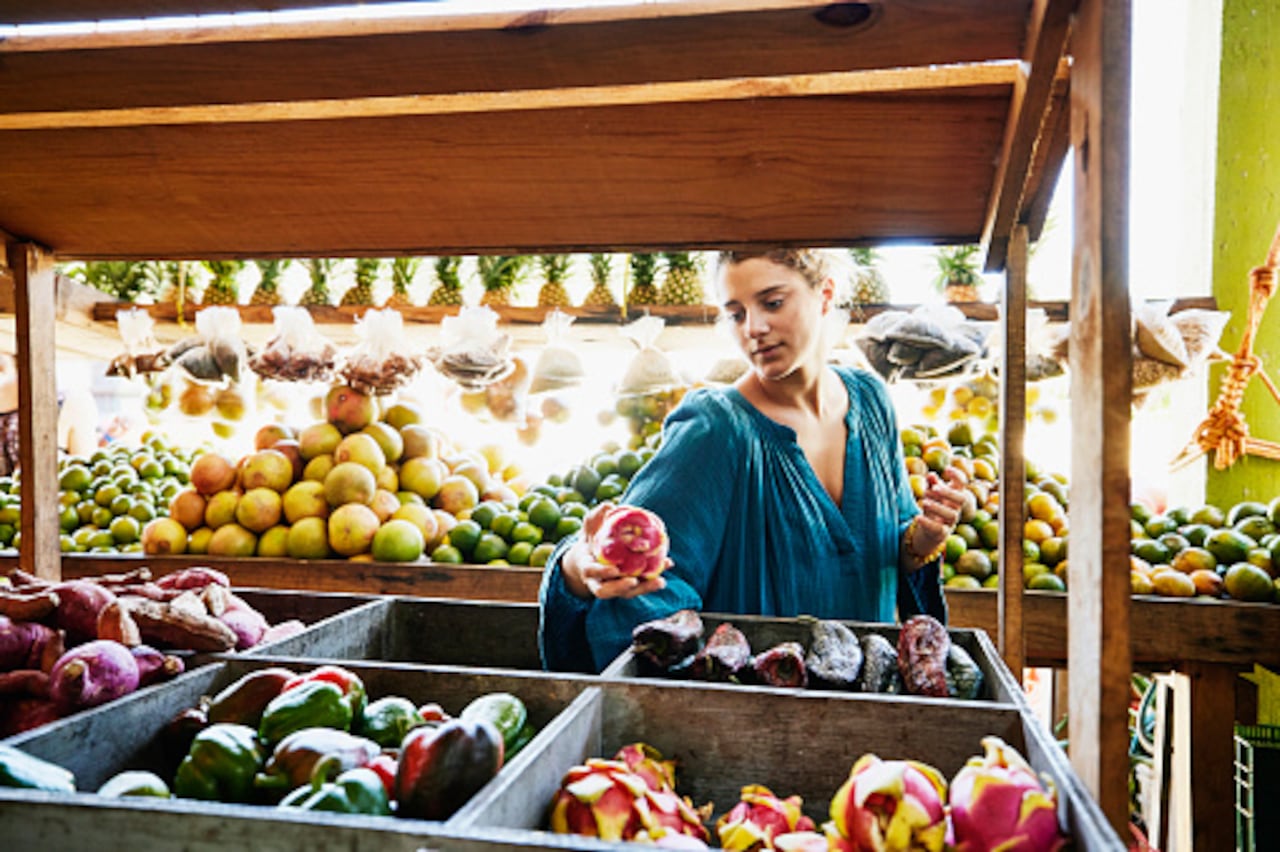 Mujer está en un supermercado escogiendo alimentos orgánicos