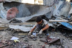A boy inspects the rubble of a collapsed building in the aftermath of Israeli bombardment at the Jaouni school run by the UN Relief and Works Agency for Palestine Refugees (UNRWA) in Nuseirat in the central Gaza Strip on July 6, 2024 amid the ongoing conflict in the Palestinian territory between Israel and Hamas. (Photo by Eyad BABA / AFP)