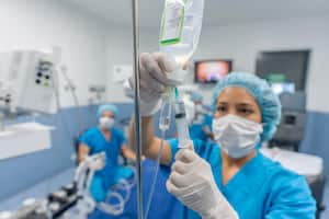 Doctor en el quirófano colocando medicamentos a través de una vía intravenosa