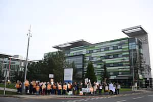 Los manifestantes sostienen pancartas mientras participan en una protesta de médicos jóvenes, en medio de una disputa con el gobierno sobre los salarios, frente al Hospital Saint Mary's.