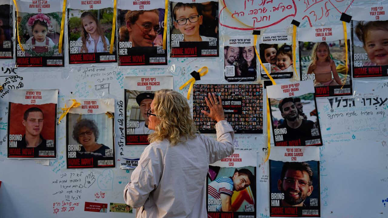 Una mujer mira fotografías de rehenes, en su mayoría civiles israelíes, que fueron secuestrados durante el ataque de Hamás contra Israel el 7 de octubre, en Tel Aviv, Israel, el viernes 24 de noviembre de 2023.