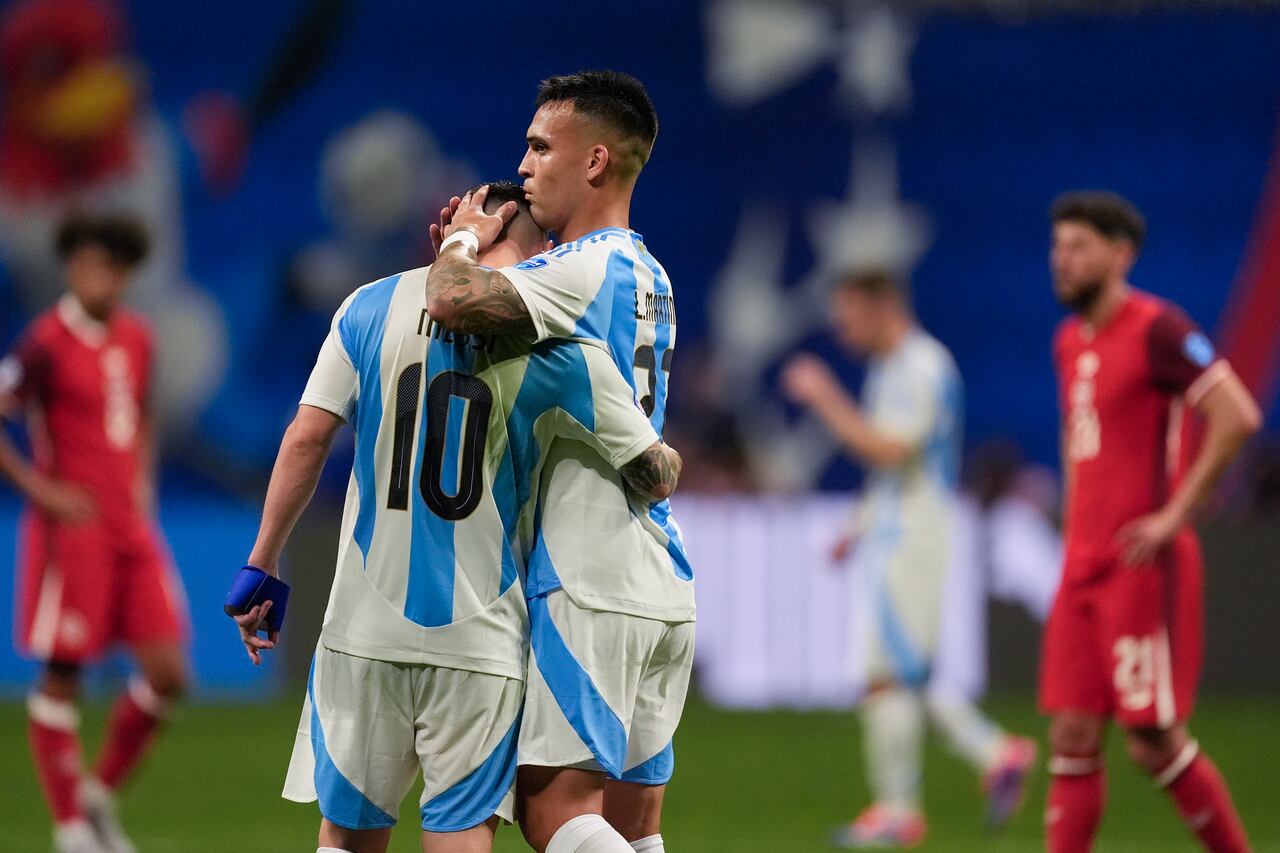 Argentina's Lautaro Martinez, right, embraces teammate Lionel Messi at the end of a Copa America Group A soccer match against Canada in Atlanta, Thursday, June 20, 2024. (AP Photo/Mike Stewart)