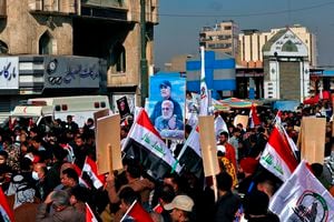 Supporters of the Popular Mobilization Forces hold a poster of Abu Mahdi al-Muhandis, deputy commander of the Popular Mobilization Forces, front, and General Qassem Soleimani, head of Iran's Quds force during a protest, in Tahrir Square, Iraq, Sunday, Jan. 3, 2021. Thousands of Iraqis converged on a landmark central square in Baghdad on Sunday to commemorate the anniversary of the killing of Soleimanil and al-Muhandis in a U.S. drone strike. (AP Photo/Khalid Moha